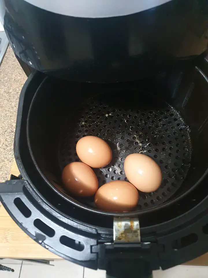 A peeling air fryer basket with eggs