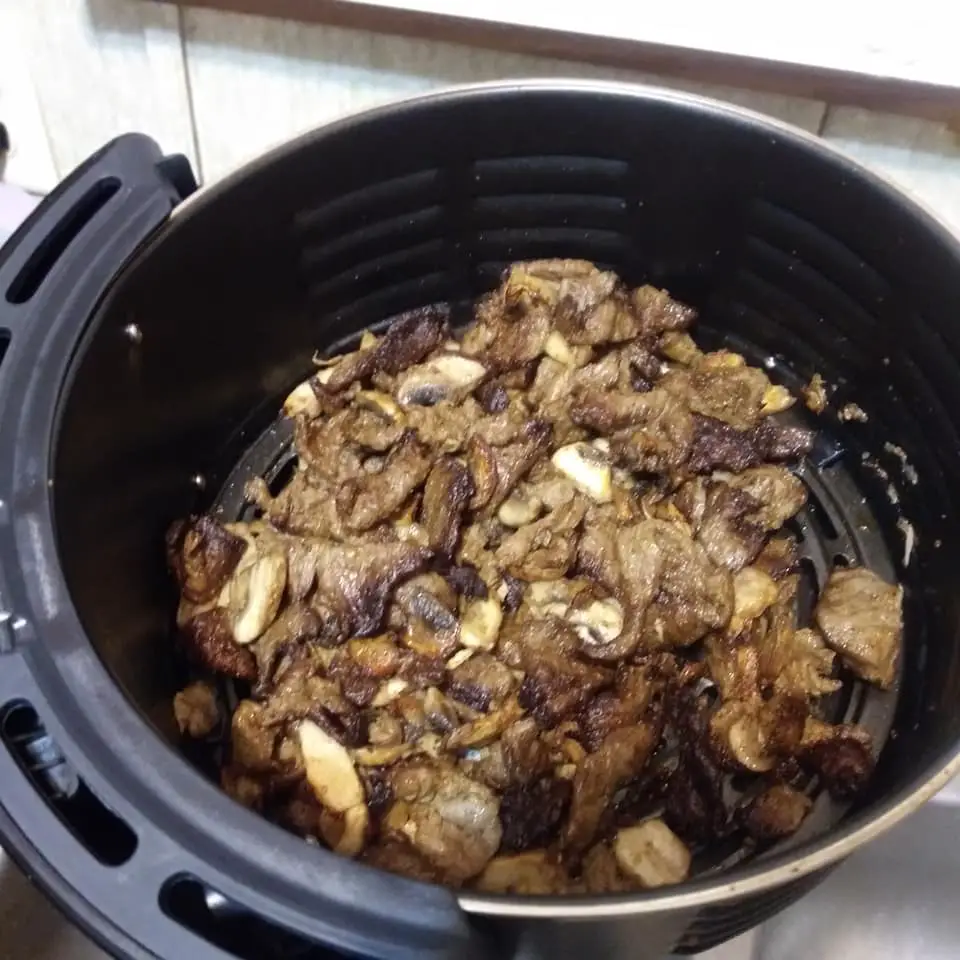 Air fryer basket with cooked mushrooms